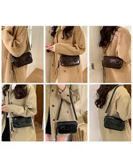 Close-up of stylish crossbody bag with vintage double buckles and decorative charm