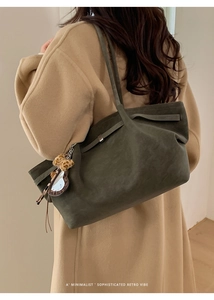 Close-up of olive green matte tote bag with shoulder strap and leopard heart charm