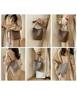 Detail view of large capacity bucket bag in brown and grey leather with adjustable strap