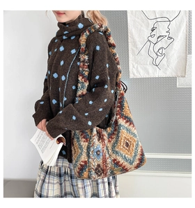 Detailansicht der Ethno-Stricktasche mit böhmischen geometrischen Mustern und Wollstruktur