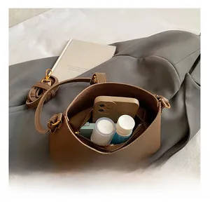 Détail montrant la capacité interne du sac à bandoulière en cuir marron grainé