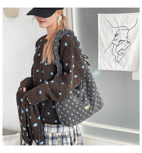 Detailansicht der grauen Plüsch-Tragetasche kombiniert mit brauner Polka-Dot-Strickjacke