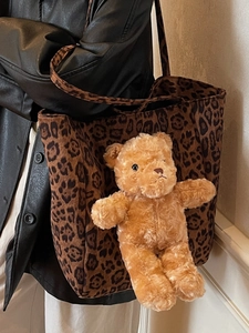 Grande borsa shopper leopardata con ciondolo a forma di orsetto marrone indossata da modella