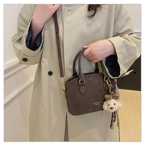 Deep brown matte handbag with FNDR fashion text and cute dog plush pendant detail