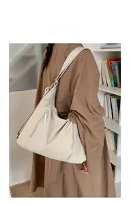 Détail du grand sac cabas crème avec fermetures éclair verticales et tissu texturé
