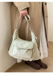 Detail of light green tote bag featuring pleated texture fabric and large front flap pocket