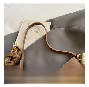 Détail d'un sac en cuir marron avec boucle rotative dorée et bandoulière réglable chic
