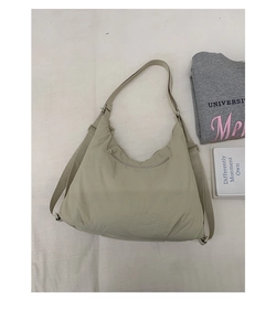Détail du sac croissant en nylon beige avec bandoulière large ajustable et poche zippée