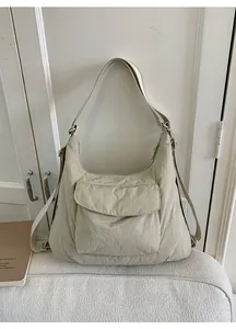 Detailed view of a beige nylon tote bag with functional pockets and versatile straps