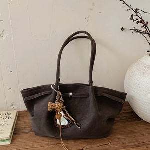 Detail of a dark brown suede tote bag with leopard bow and silver square buckle