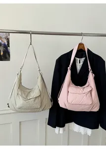 Detail of nylon tote bags in beige and pink with large flap pockets and wrinkled texture