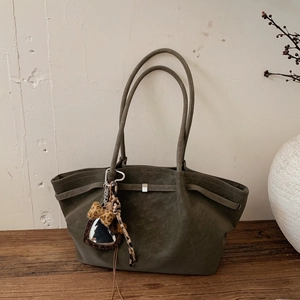 Close-up of olive green suede tote bag with silver buckle and leopard heart charm