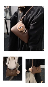 Détail d'un sac à bandoulière en cuir marron avec un joli pendentif en peluche
