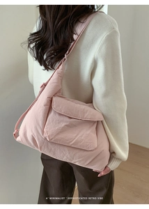 Pink quilted shoulder bag with front flap pocket shown on model in minimalist setting