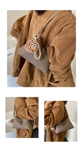 Détail du sac à bandoulière gris texture litchi avec fermoir doré et charme peluche