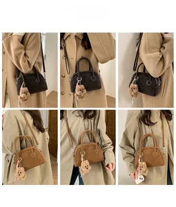 Dettaglio che mostra le borse Boston vintage in marrone scuro e chiaro con ciondoli a orso