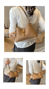 Détail du sac bandoulière marron grainé avec fermoir doré et pendentif en peluche