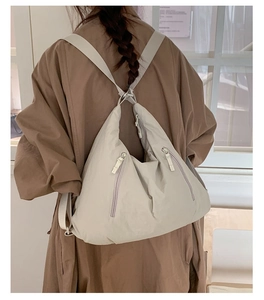 Détail du sac fourre-tout en nylon beige avec double fermeture éclair et texture douce