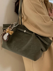 Retro olive green suede tote bag with leopard bow and mirror charm on model shoulder