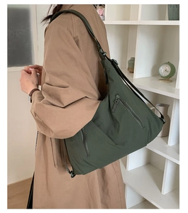 Détail du sac fourre-tout en nylon vert sur l'épaule avec bandoulière réglable et tissu