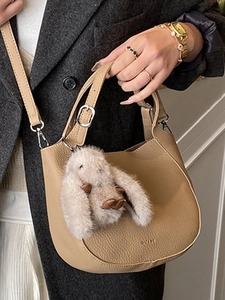 Chic khaki pebbled leather bucket bag with plush bunny charm for daily commuting style