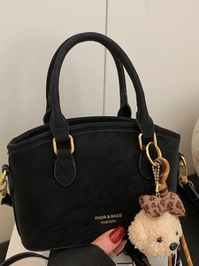 Chic black matte crossbody bag with golden metal hardware and a leopard bow plush charm