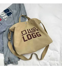 Detail view of khaki canvas tote bag with brown LOGG print and metal magnetic closure