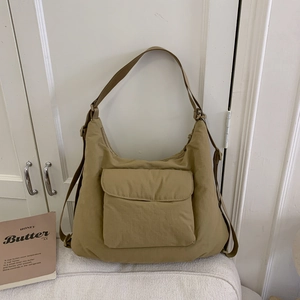 Detail of khaki nylon tote bag with large front pocket and adjustable shoulder strap