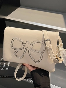 Chic cream square crossbody bag with rivet bow pattern and elegant pearl heart charm