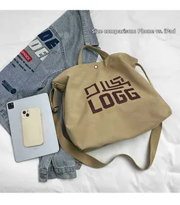 Detailed size comparison of the khaki canvas tote bag with a tablet and mobile phone
