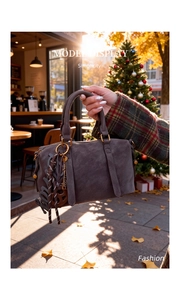Detail of Boston bag with leather handles, gold hardware, and creative decorative pendants