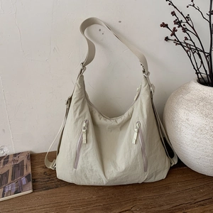 Détail du sac fourre-tout en nylon blanc cassé avec poches zippées et bandoulière