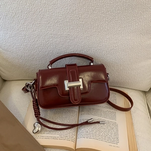 Detailed view of the burgundy vintage square bag with a silver heart charm and metal lock
