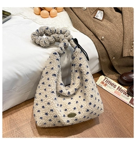 Detailansicht der Winter-Plüschtasche mit blauen Sternen und metallischer Logoplakette