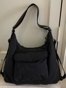 Minimalist black quilted tote bag with multi-pocket design and adjustable shoulder strap