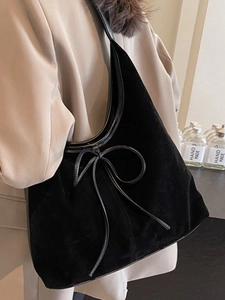 Chic black velvet tote bag with a bow detail for women's winter commute fashion
