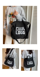 Detail view of black canvas tote bag showing double straps and LOGG printed graphic
