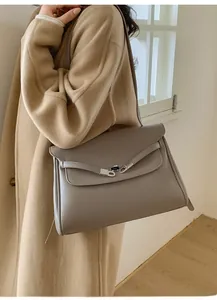 Close-up of grey leather tote bag with lychee texture and silver metal clasp detail