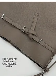 Detailaufnahme der Ledernarbung und silbernen Metallschnalle der Eimertasche in Grau
