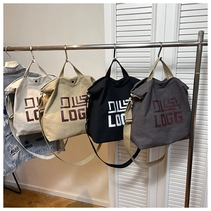 Detail view of four minimalist canvas tote bags in ivory, khaki, black and grey colors