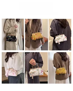 Detail view of Chinese style embroidery clutch bag with chain and tassel accessory