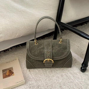 Detail of olive green vintage leather handbag with contrast stitching and golden buckle
