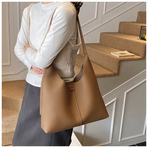 Detail der minimalistischen braunen Tragetasche mit hochwertigem genarbtem Leder und Gurt
