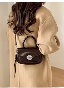 Brown oil wax leather crossbody bag styled with a wool coat for a chic winter look