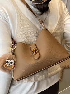 Sac bandoulière marron grainé avec fermoir rotatif doré et charme de monstre en peluche
