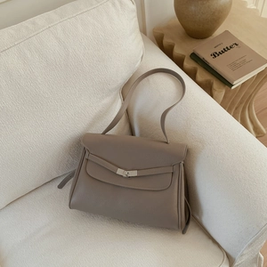 Close-up of taupe litchi grain leather tote bag with elegant silver V-shaped buckle