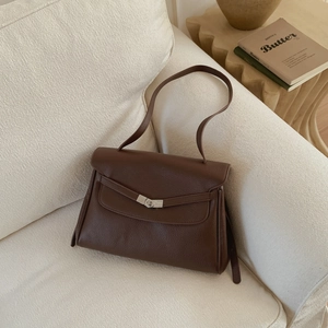 Detail view of dark brown lychee grain leather tote with a silver V-shaped metal buckle