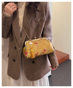Detail of yellow floral shell bag with elegant tassel and gold chain on model
