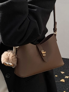 Sac à bandoulière demi-lune en cuir marron avec un charmant pendentif monstre en peluche