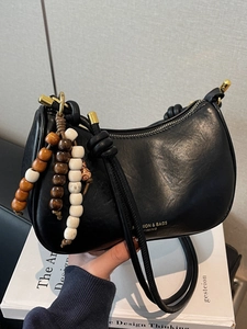 Minimalist black matte leather half-moon shoulder bag with vintage wooden bead charms